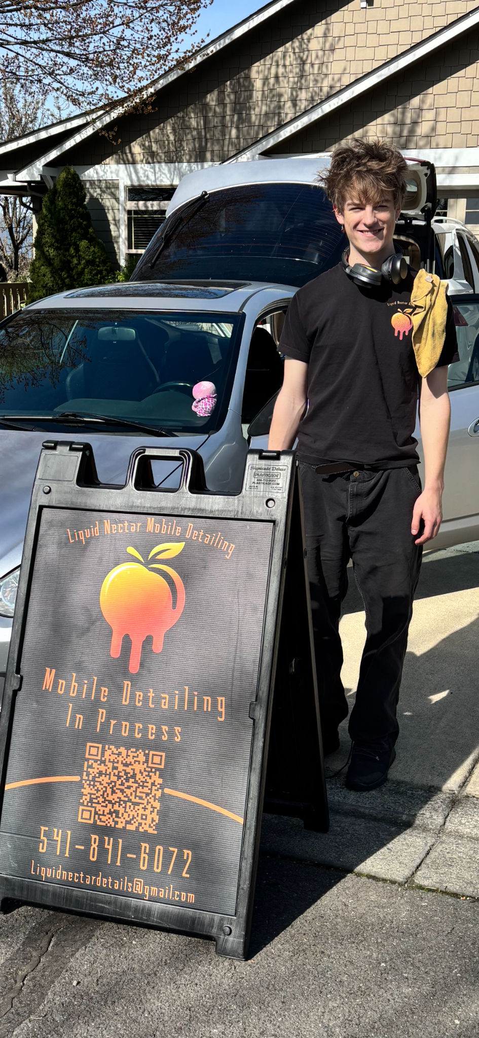 Owner of Liquid Nectar standing by the mobile detailing sign